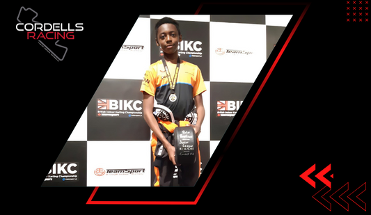 Young Cordell's Racing competitor holding a trophy and wearing a medal at a karting championship.
